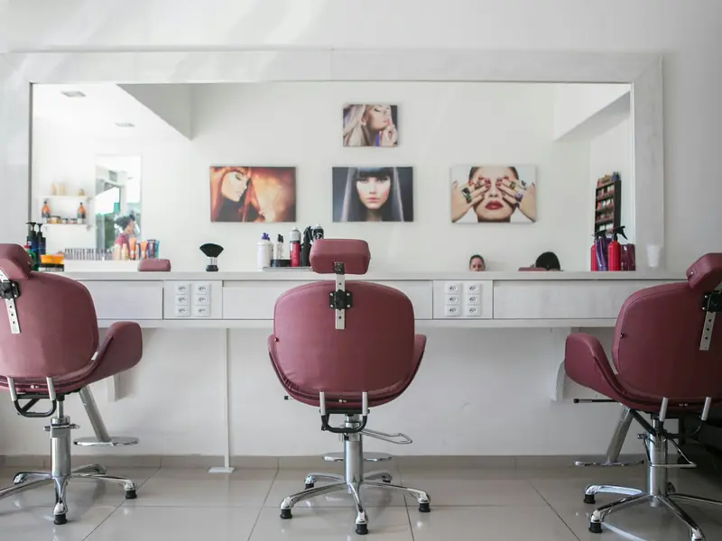 Salón de peluquería con sillones y espejos